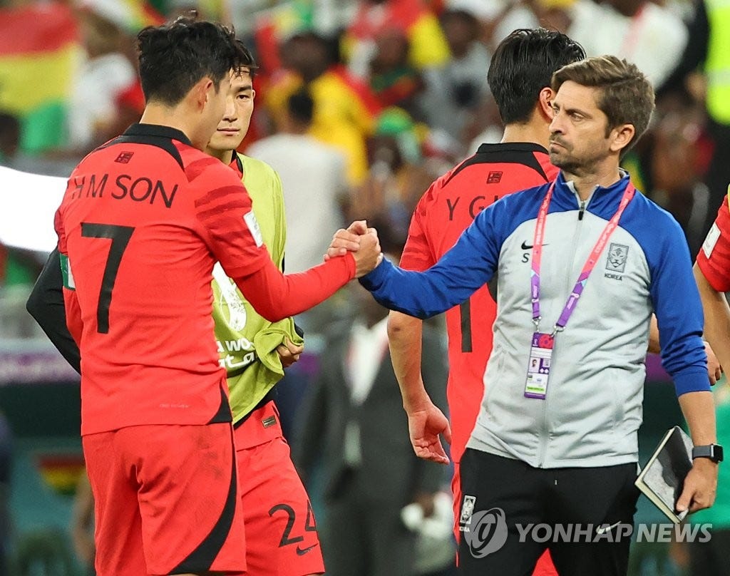 South Korea assistant coach Sergio Costa (R) shakes hands with his captain Son Heung-min after South Korea's 3-2 loss to Ghana in the teams' Group H match at the FIFA World Cup at Education City Stadium in Al Rayyan, west of Doha, on Nov. 28, 2022. (Yonhap)