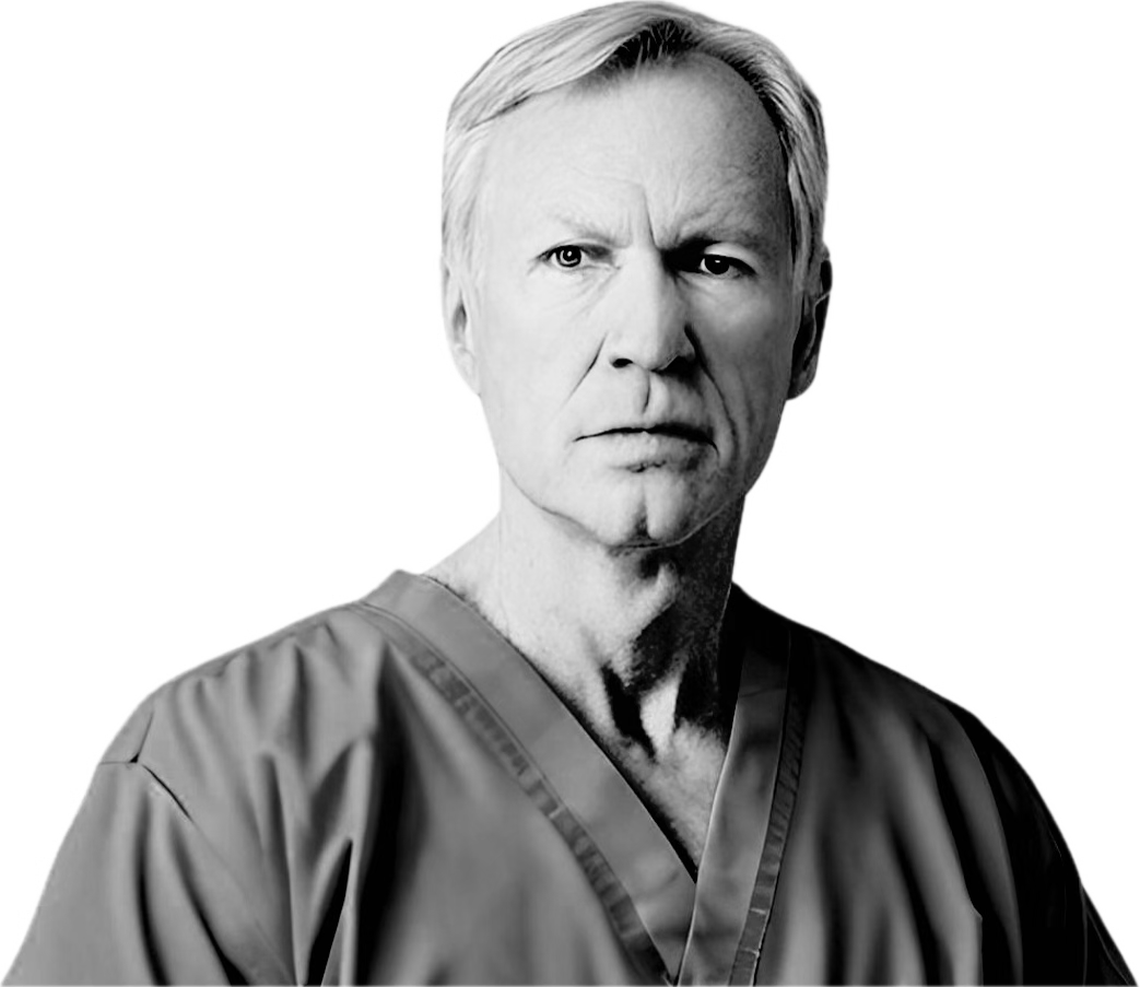 A black and white photo of an older white man with white hair looking forward with a concerned look on his face