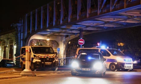 Police vans and a car parked under a bridge