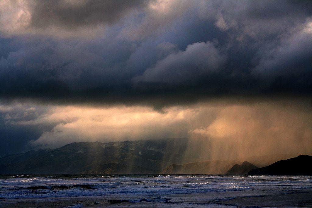 Sunbreak in grey clouds over a seacoast