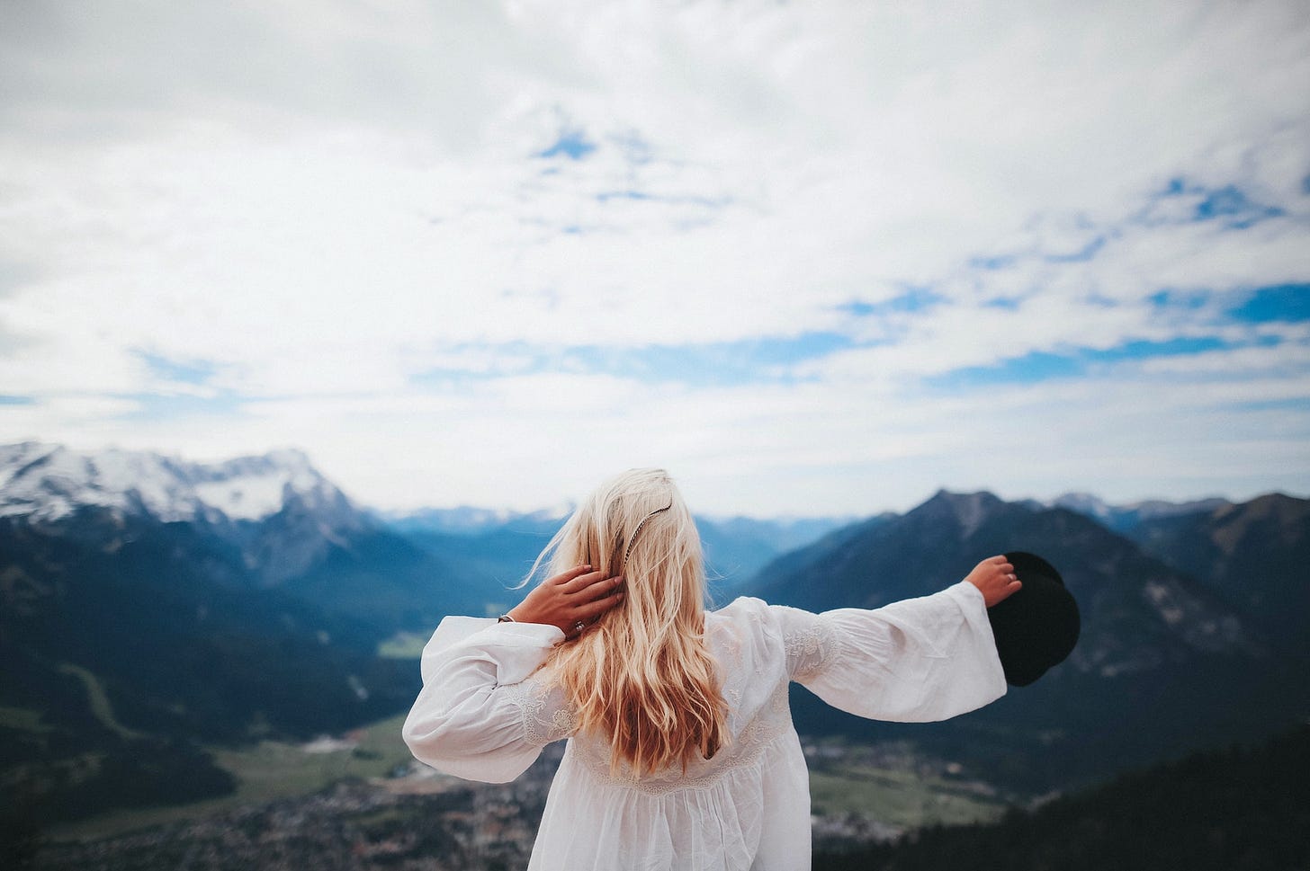 Back view of woman with white dress on mountain top view