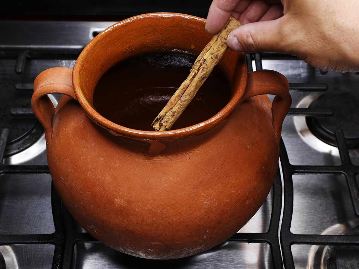 adding cinnamon stick to clay pot