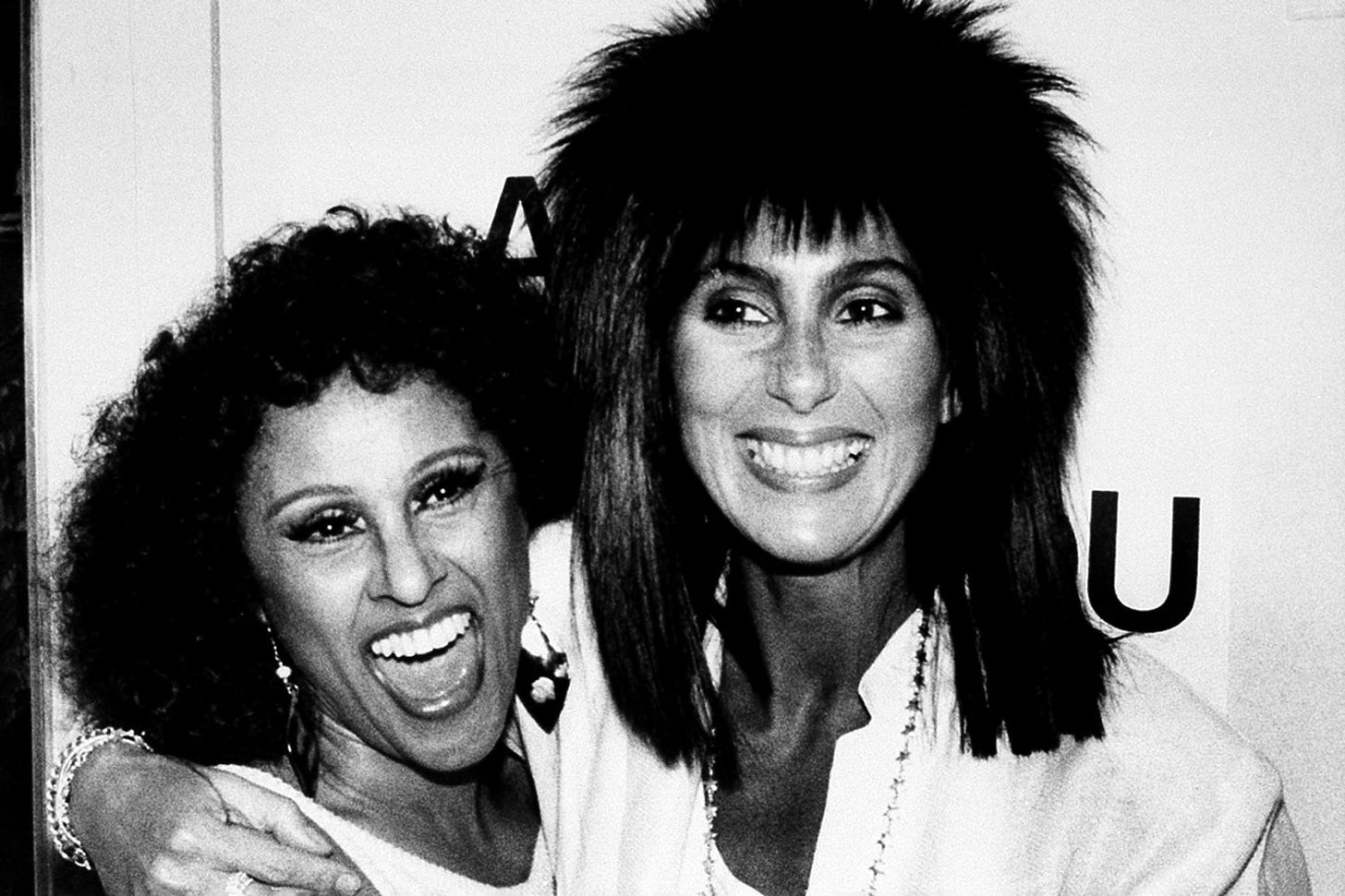 Cher hugs her friend Darlene Love after a performance of "Leader of the Pack" at the Ambassador Theatre in New York City, Friday night, July 20, 1985.  Love is starring in the Broadway musical.  (AP Photo/Frankie Ziths)