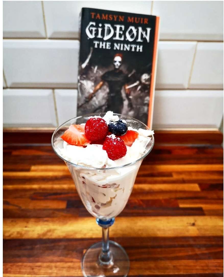 Gideon the Ninth and a delicious looking dessert of eton mess in a glass