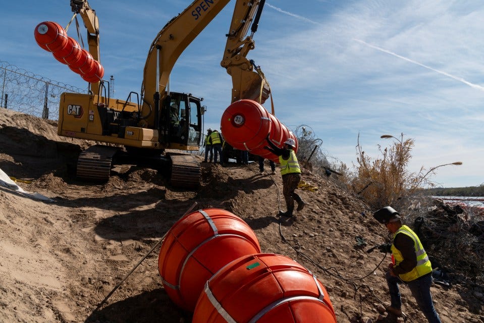 Workers installing buoys in a river to deter migration.