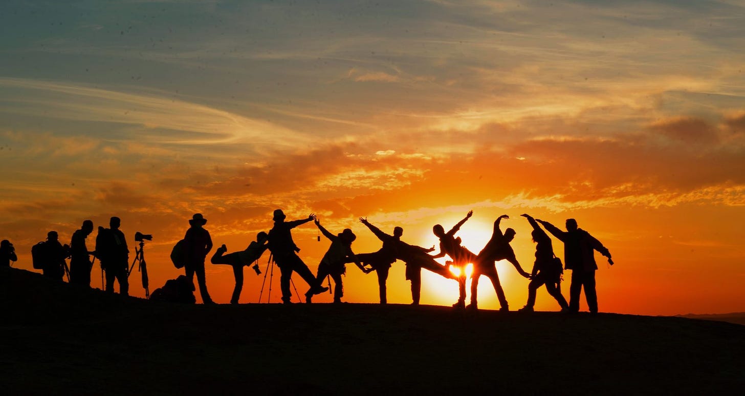 folks silhouetted across the sunset