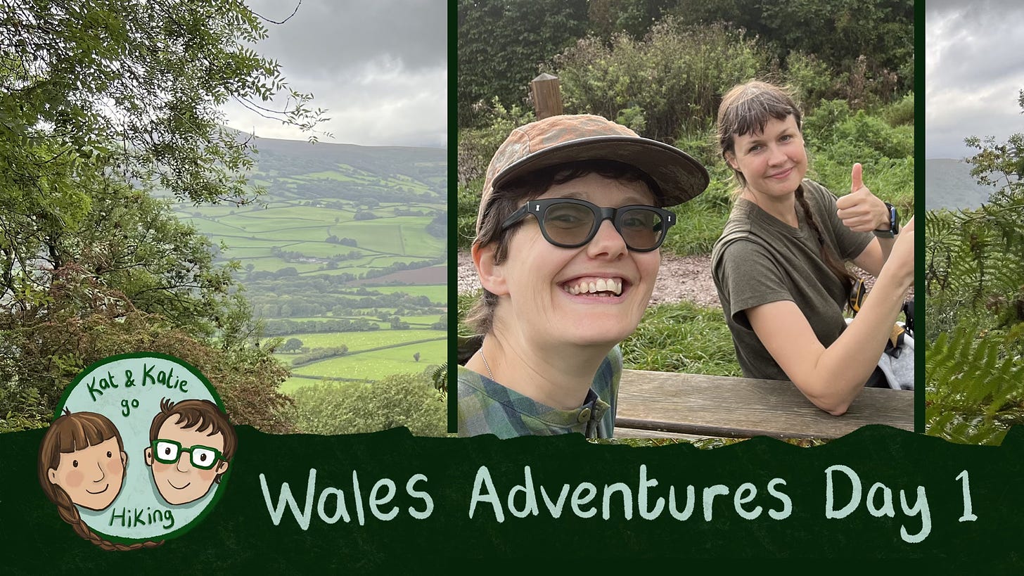 Title card for a video. Two friends grin at the camera in front of beautiful green scenery. Text reads "Wales Adventures Day 1"