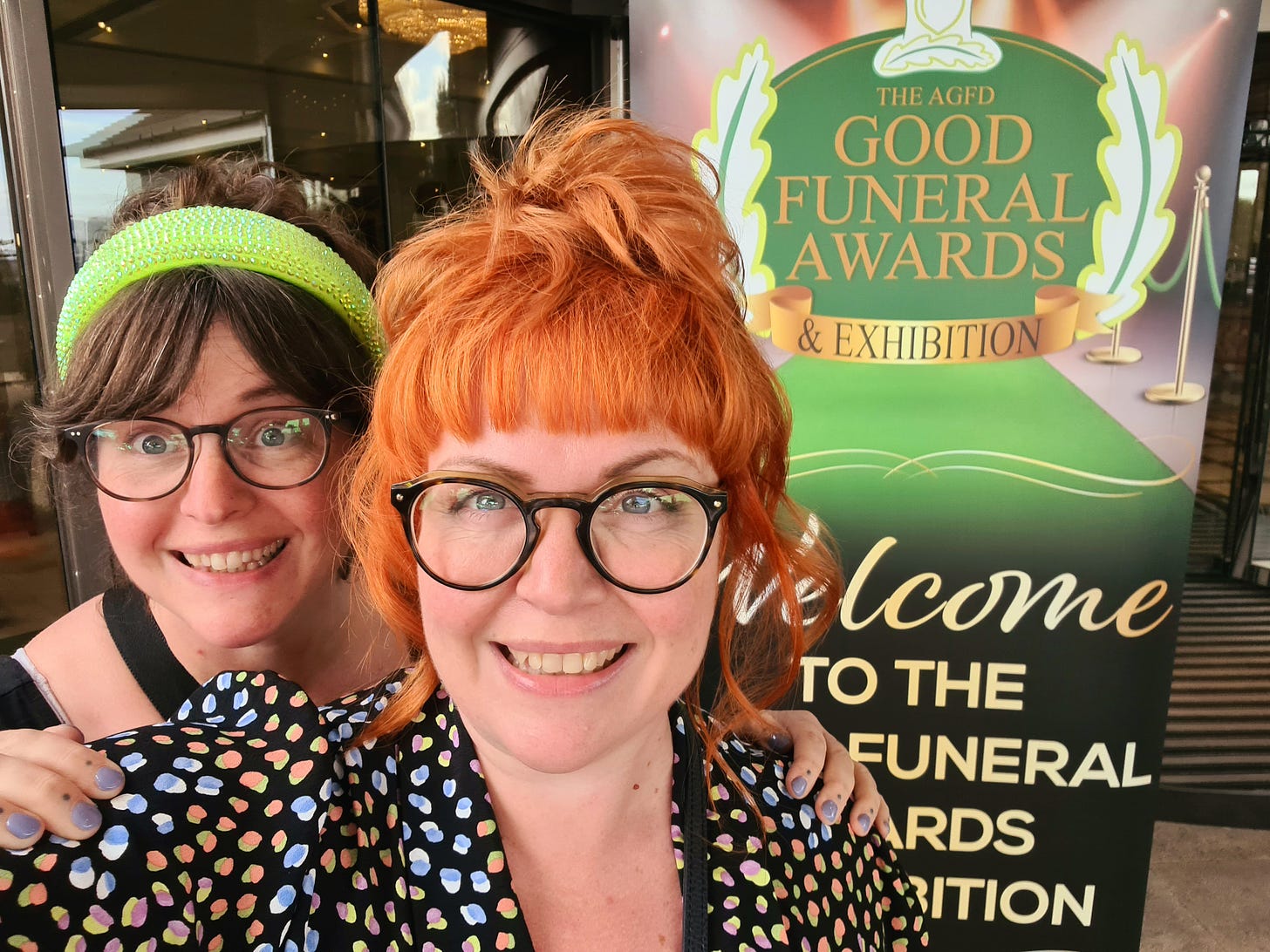 Close up of LV & KV in front of The Good Funeral Awards banner in 2023