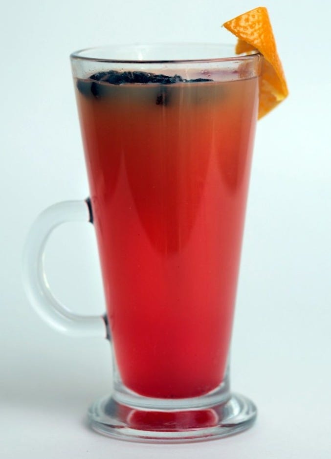 A red drink with a slice of orange on top of it A red drink with a slice of orange on top of it