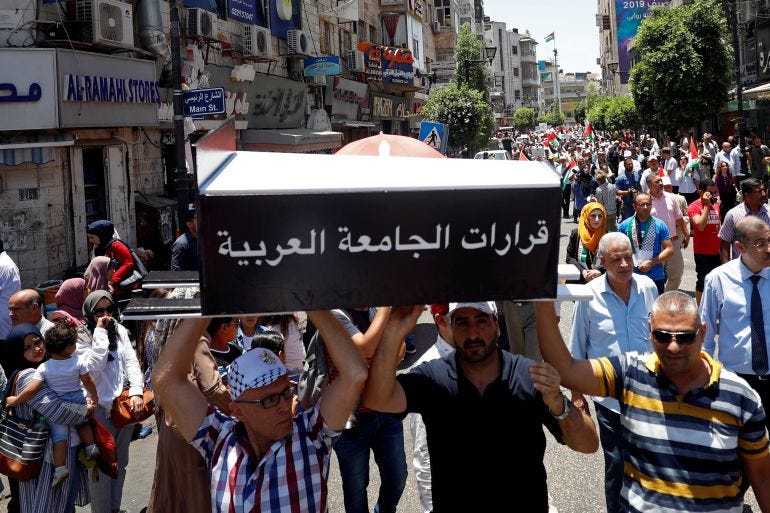 Palestinian demonstrators carry a symbolic coffin reading: "the resolutions of the Arab League" during a protest against Bahrain's workshop for U.S. peace plan, in Ramallah, in the Israeli-occupied West Bank June 24, 2019. REUTERS/Mohamad Torokman