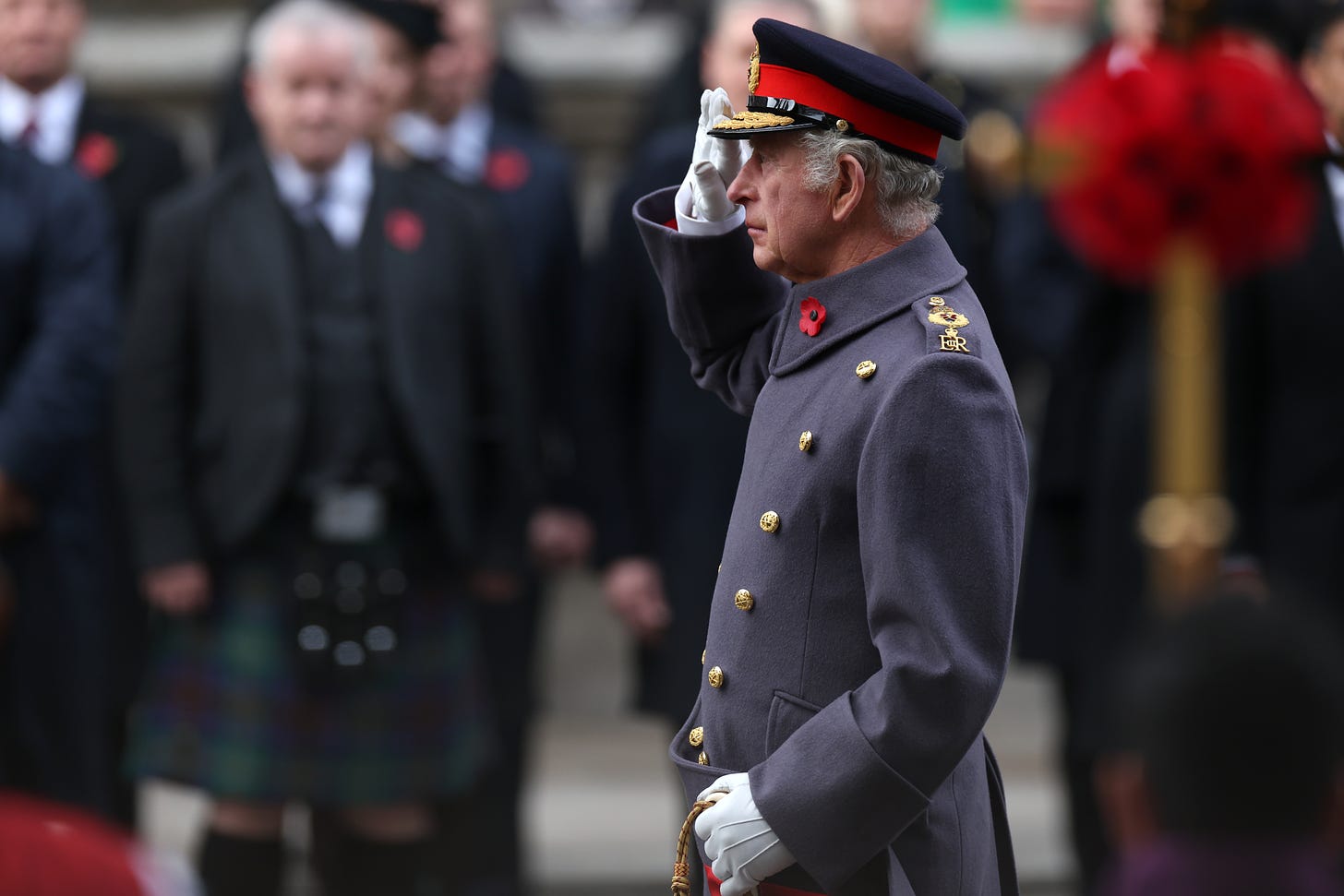 King Charles wearing military uniform and saluting