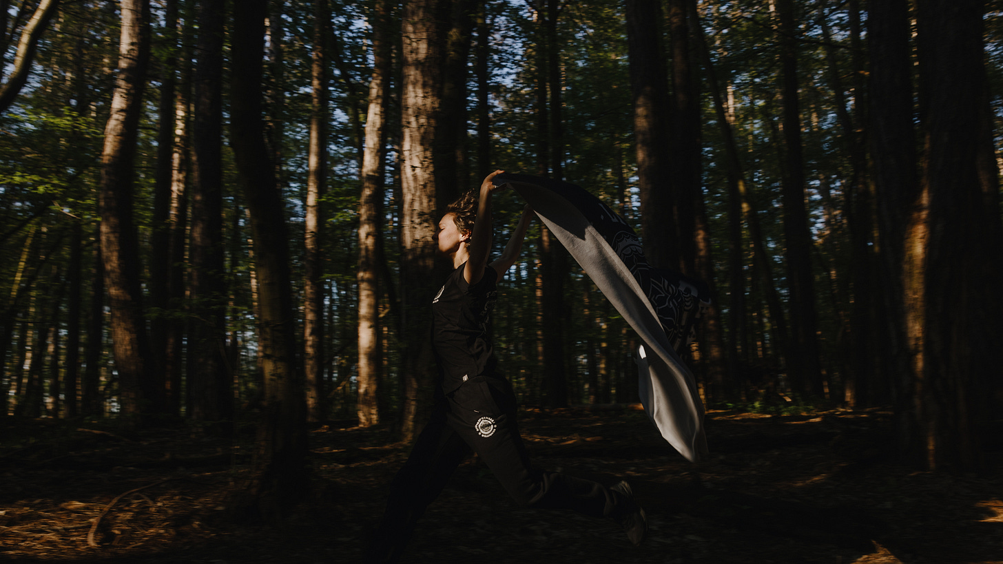 Female runner dancing in the woods