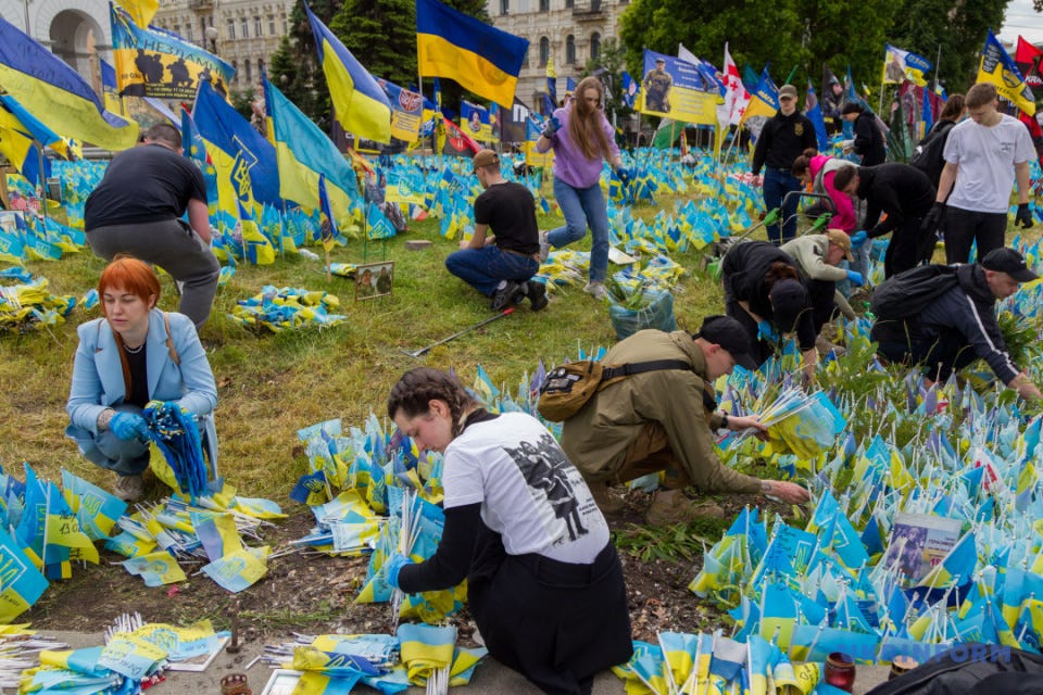 Активісти поруч з прапорцями з іменами загиблих на війні захисників під час толоки на Майдані Незалежності / Фото: Кирило Чуботін. Укрінформ