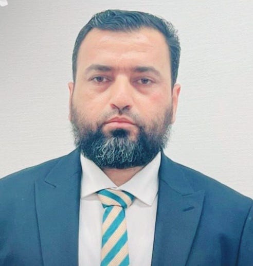 A person in a suit and tie

AI-generated content may be incorrect.