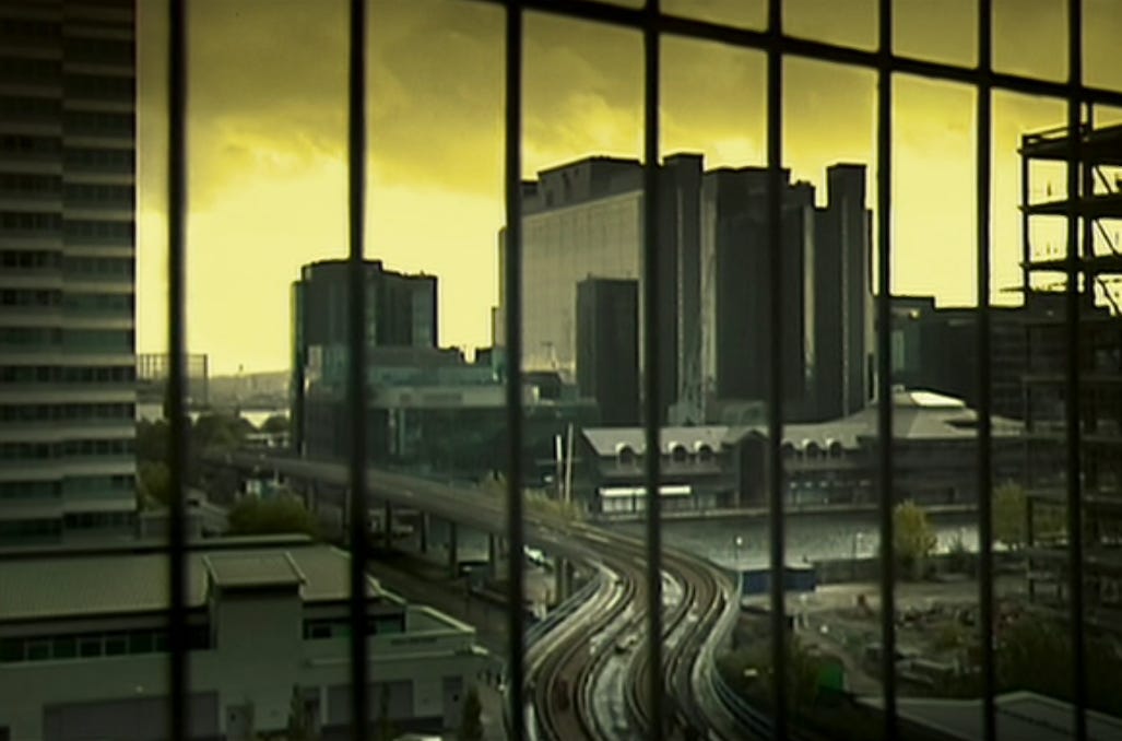 Movie still from 28 Days Later. A shot of a city skyline with a highway, behind a barred window.