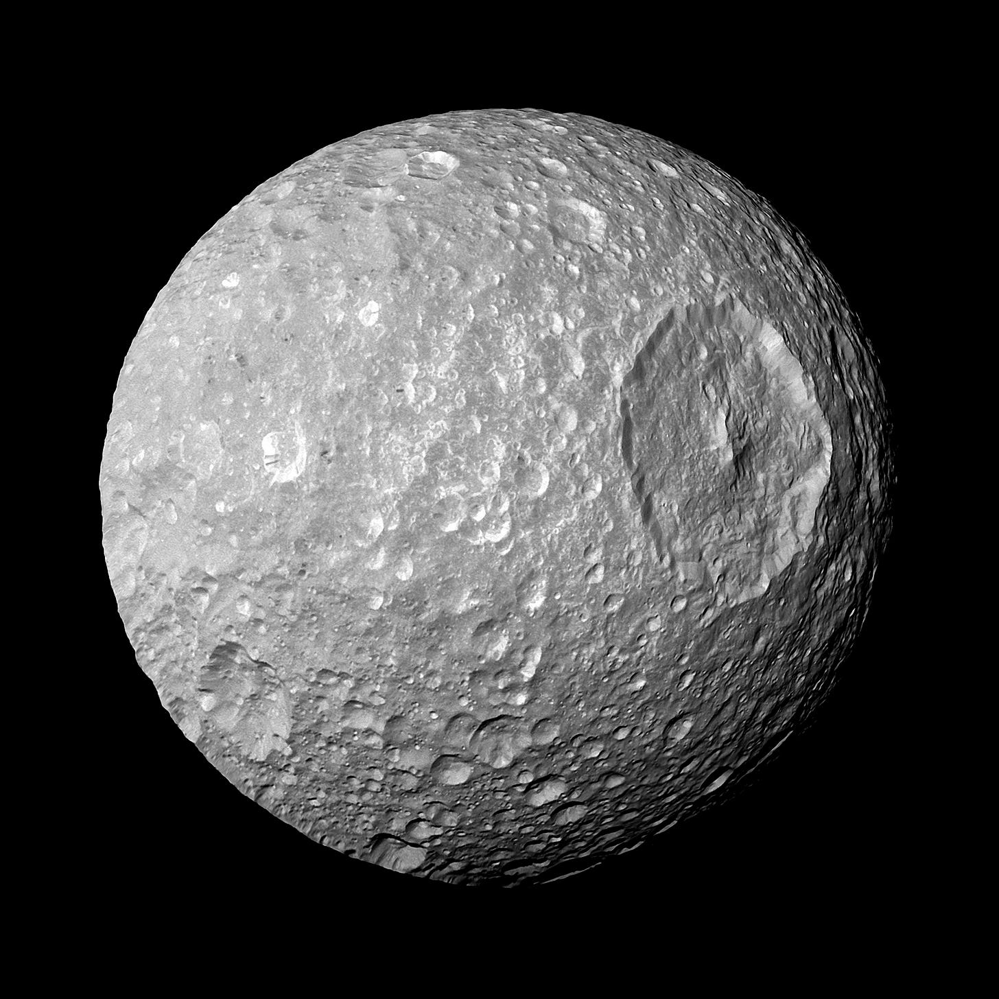 Photo of Saturn's moon Mimas in space and it's large Herschel Crater.