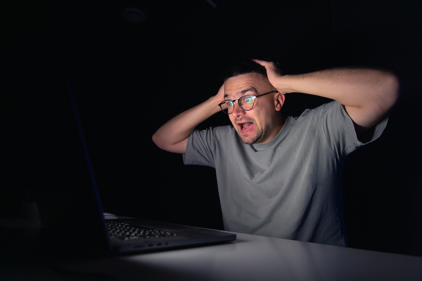 A person overwhelmed by choice, looking shocked at a laptop