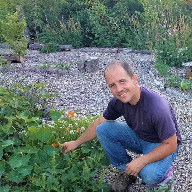 Daron, the author of this article, in his front yard that has been planted with native plants.