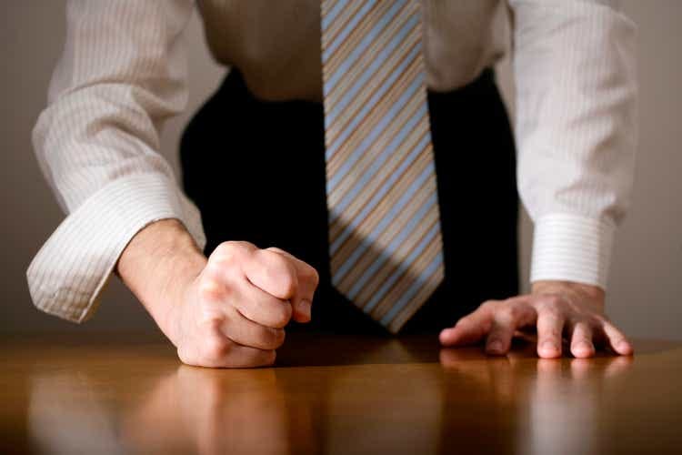 Close-up of a determined man with his fist on the table