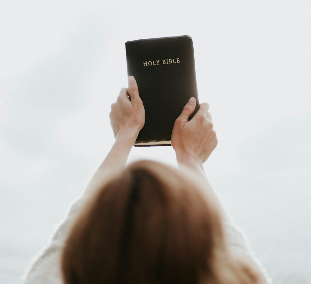 person holding Holy Bible person holding Holy Bible