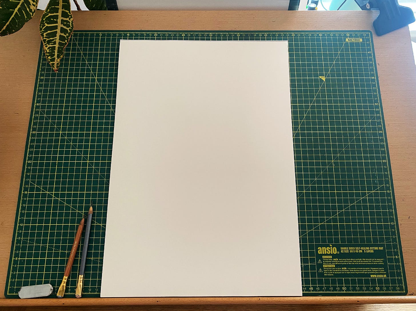 A photograph of Adam's desk with a sheet of blank A3 paper on it