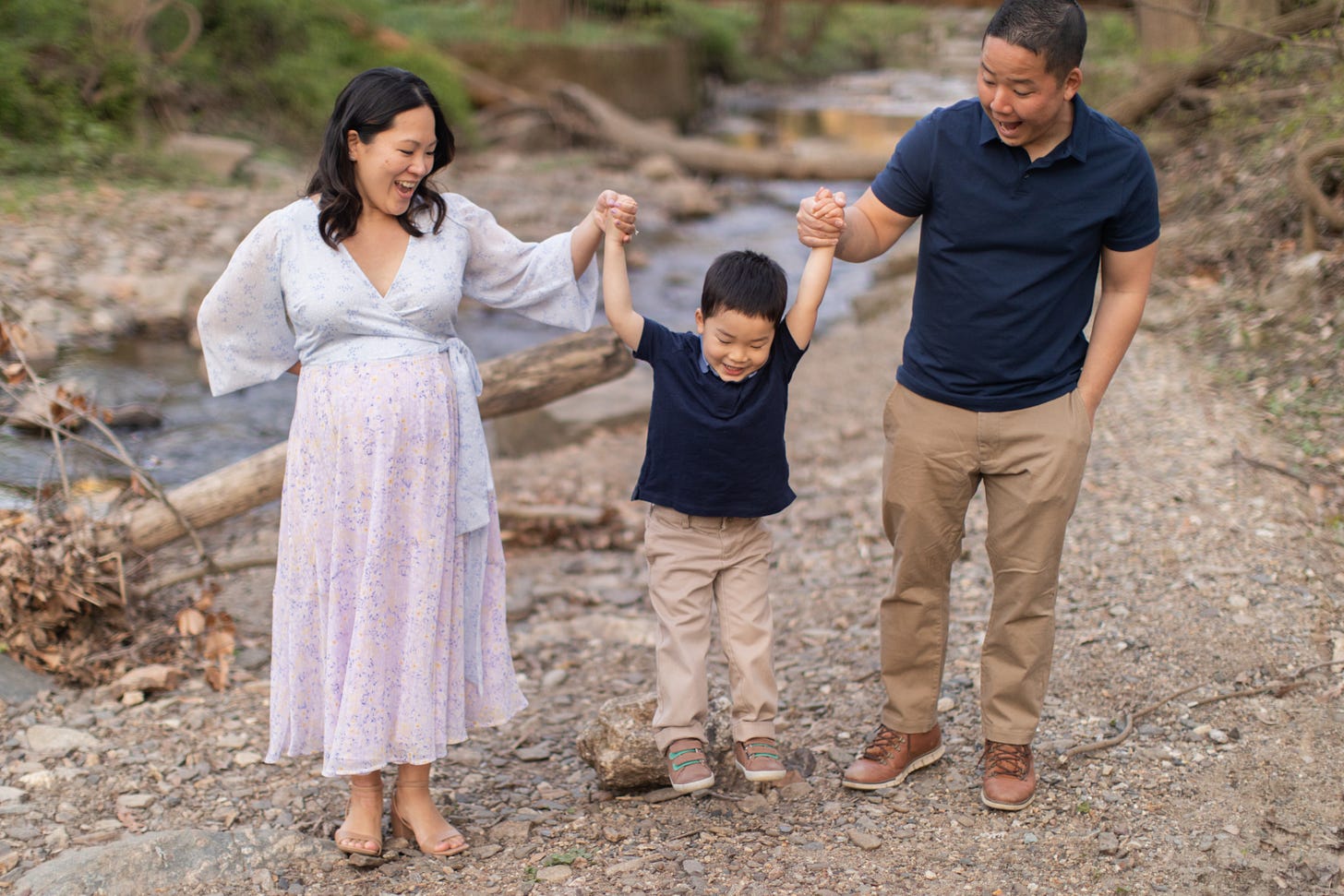 An Asian American Family laughing together during a maternity session at a park.