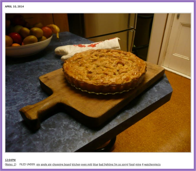 Ursula's Tumblr | Photo of apple pie on a chopping block, an oven mitt lies next to it. Behind, a bowl of fruit.
