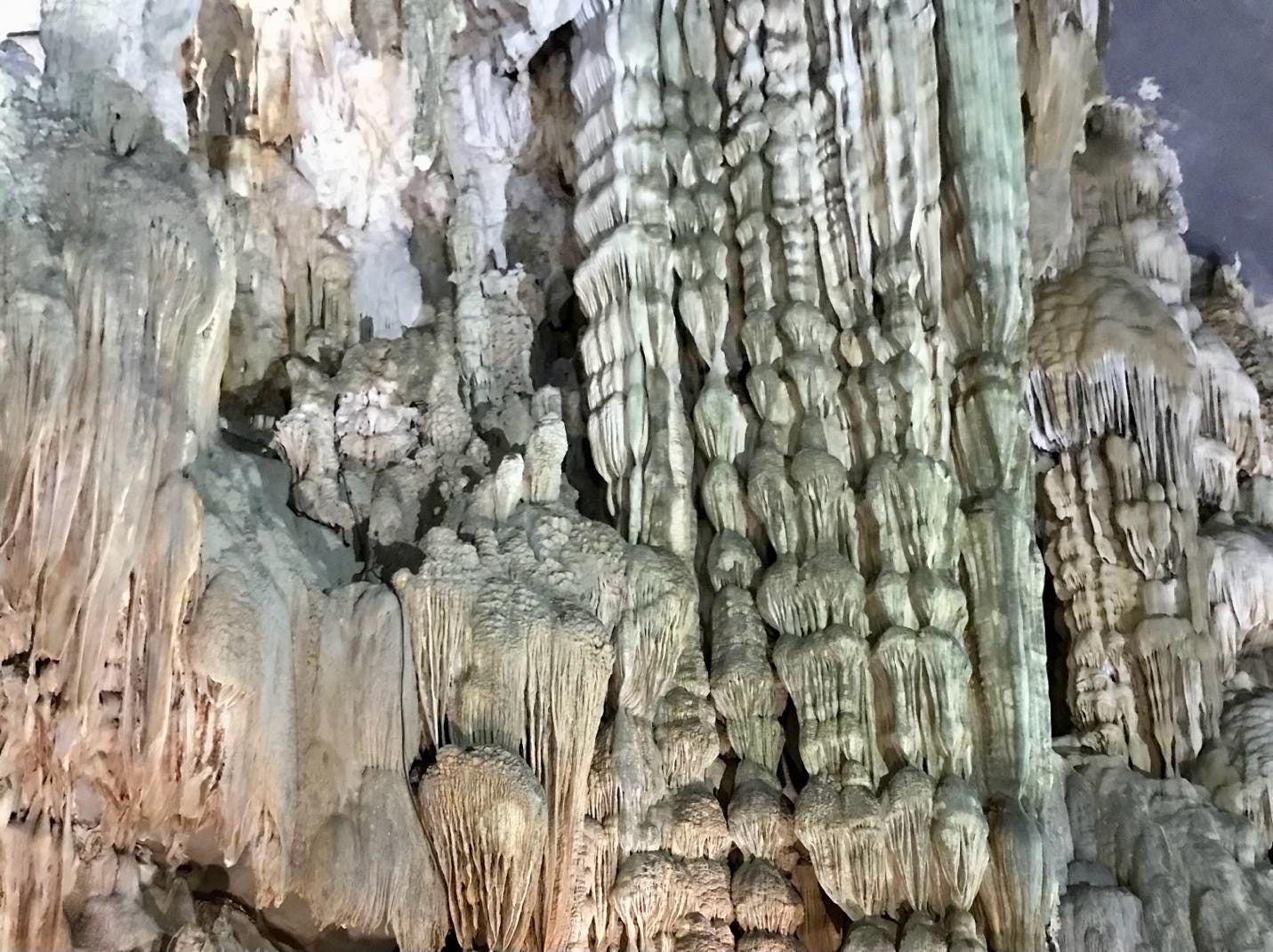 Pink, beige and light green rock formations in an underground cave grotto Phong Nha, Thailand