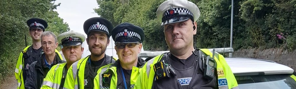 Six uniformed special constables at the roadside next to a police car