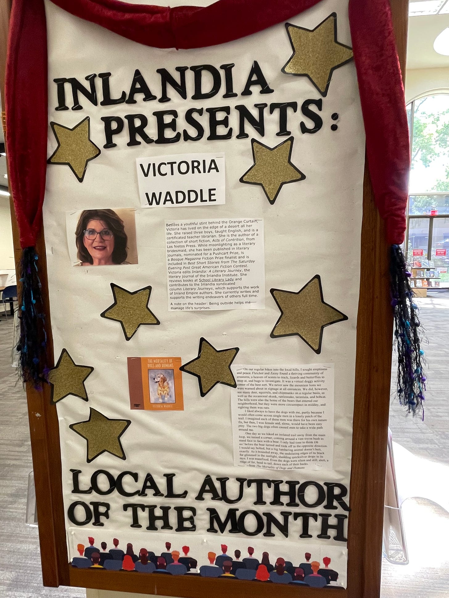 A bulletin board with an image of teh author, a few stars, a book cover with a dog and some quotes from her work.