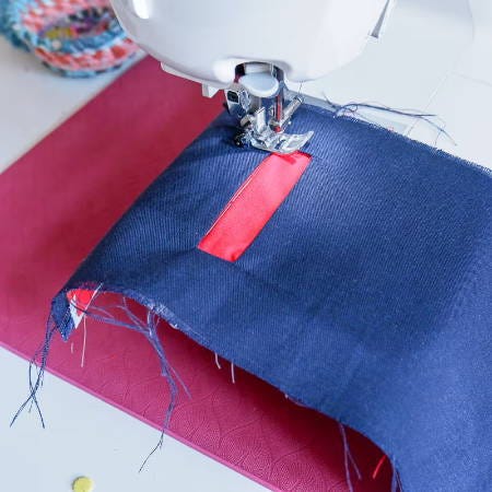 Sewing with a sewing machine all around the welt pocket opening through all layers