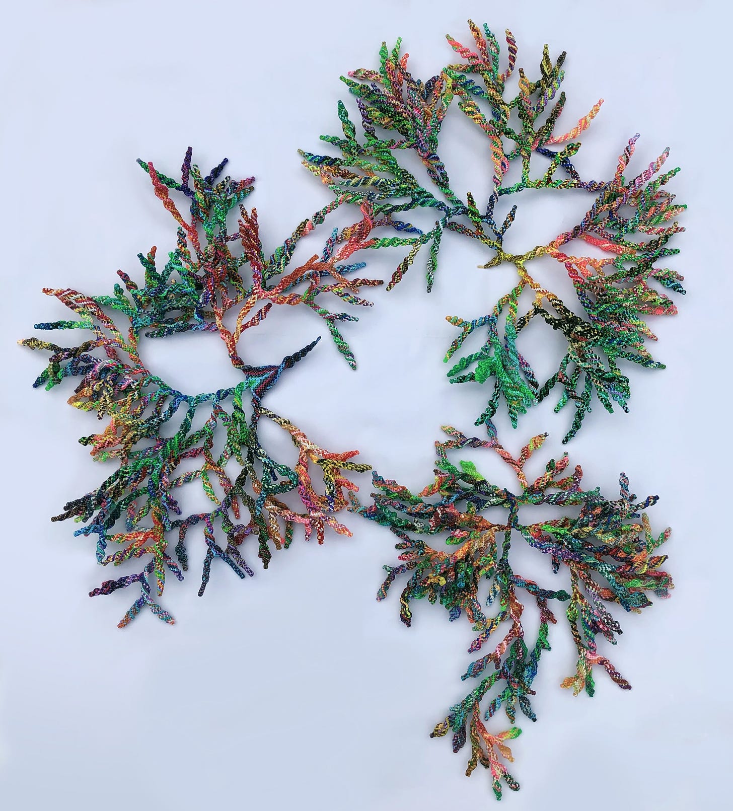 Multicolored branches made of lanyard. This interactive sculpture is formed of three large parts that can be displayed together or separately in various positions. As they spread out, the organic, colourful and ever-changing shapes mirror corals, lichens, and other organisms found in nature.