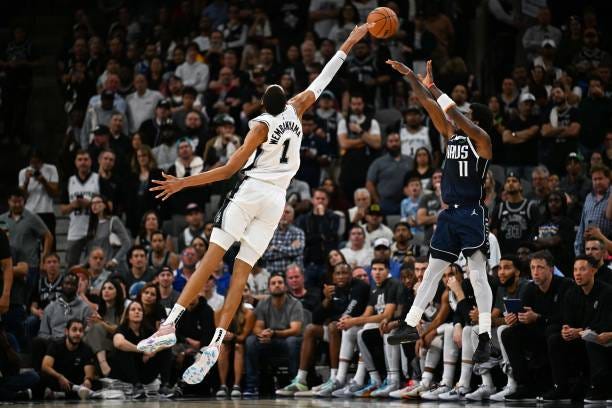 San Antonio Spurs' French forward-center Victor Wembanyama jumps to block a shot by Dallas Mavericks' Australian-US point guard Kyrie Irving during...