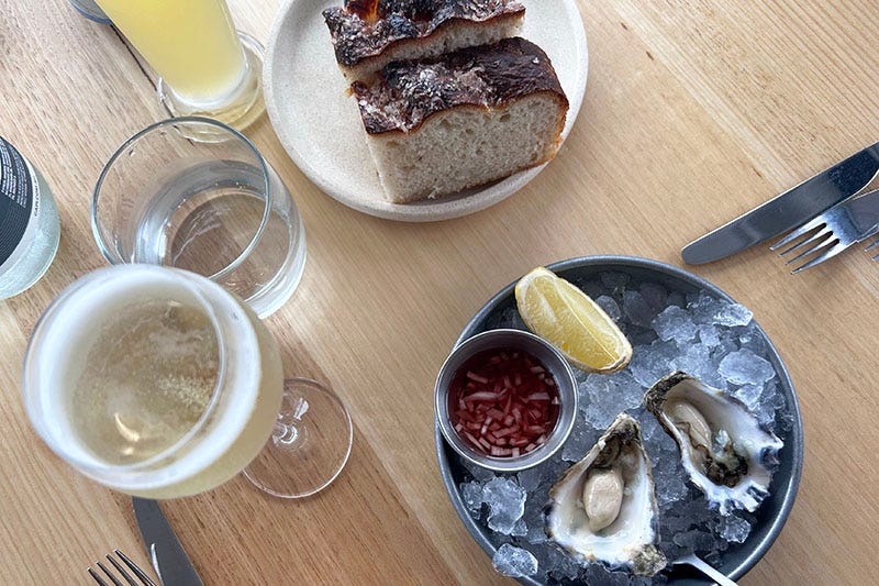 Prosecco, focaccia and oysters from Sodafish on a table.