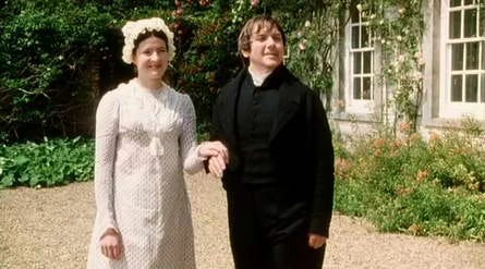 Mr. and Mrs. Collins stand waiting to receive guests outside their home. 