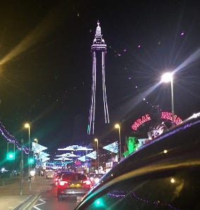 Blackpool Tower during the illuminations, Bright lights, car roof. Slow traffic.
