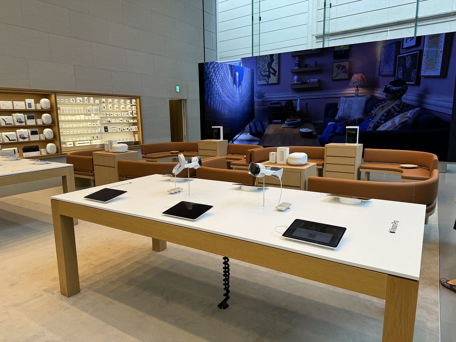 The Demo Zone at Apple Omotesando. Two Spotlight Tables and two sets of sofas are placed in front of the video wall.