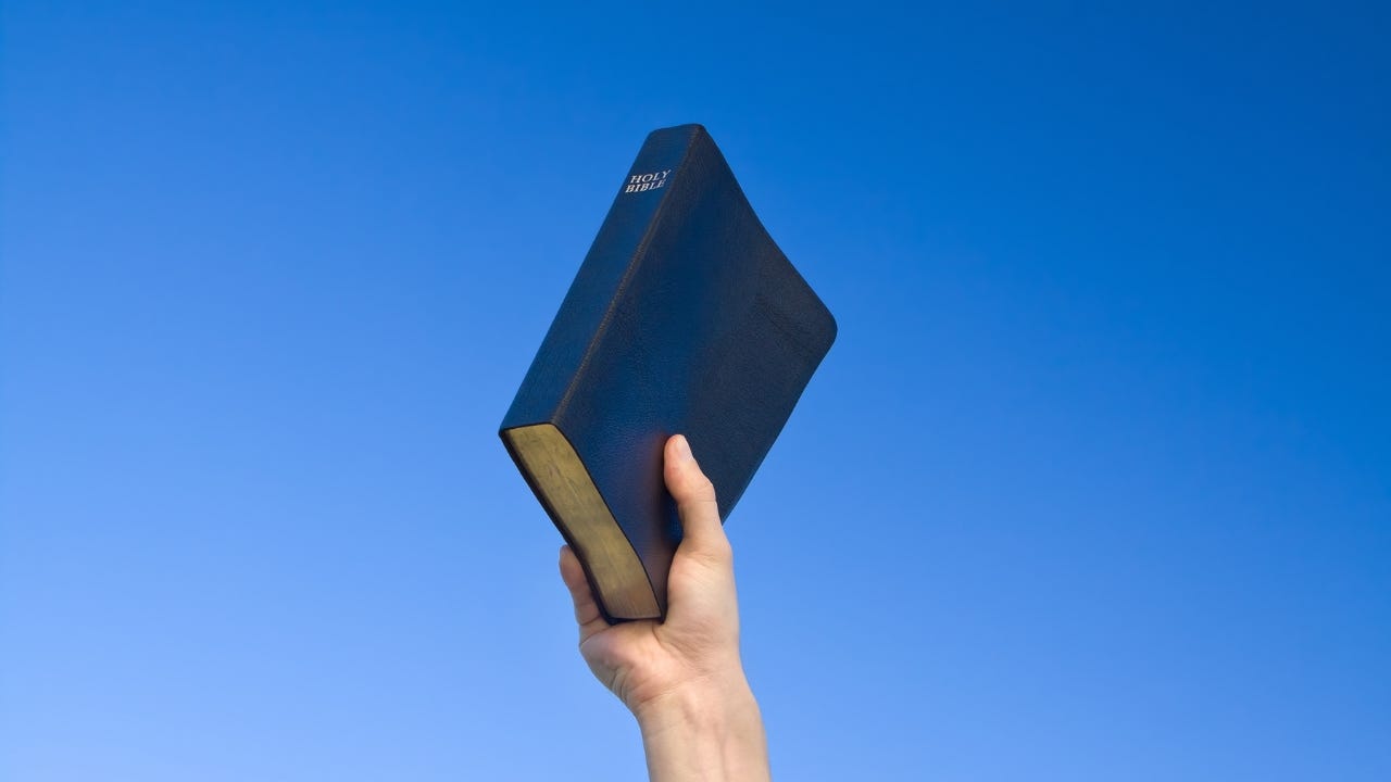 A person holding up the Bible.