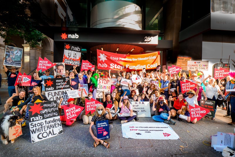 Photo of a large group of activists outside the NAB Brisbane City Branch
