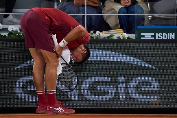 Novak Djokovic of Serbia dries his face with a towel during his match against Lorenzo Musetti of Italy in the Men's Singles third round match on Day...