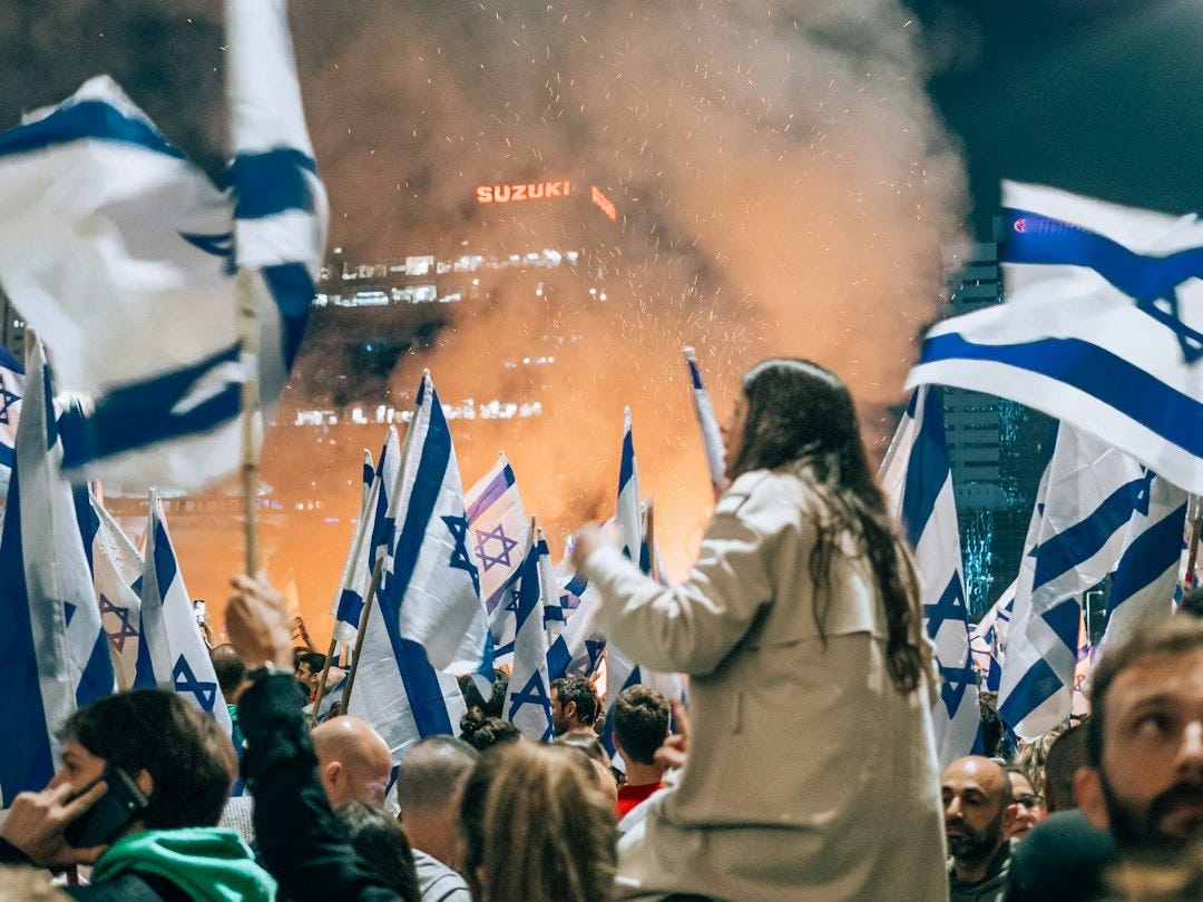 a large group of people holding flags in front of a crowd