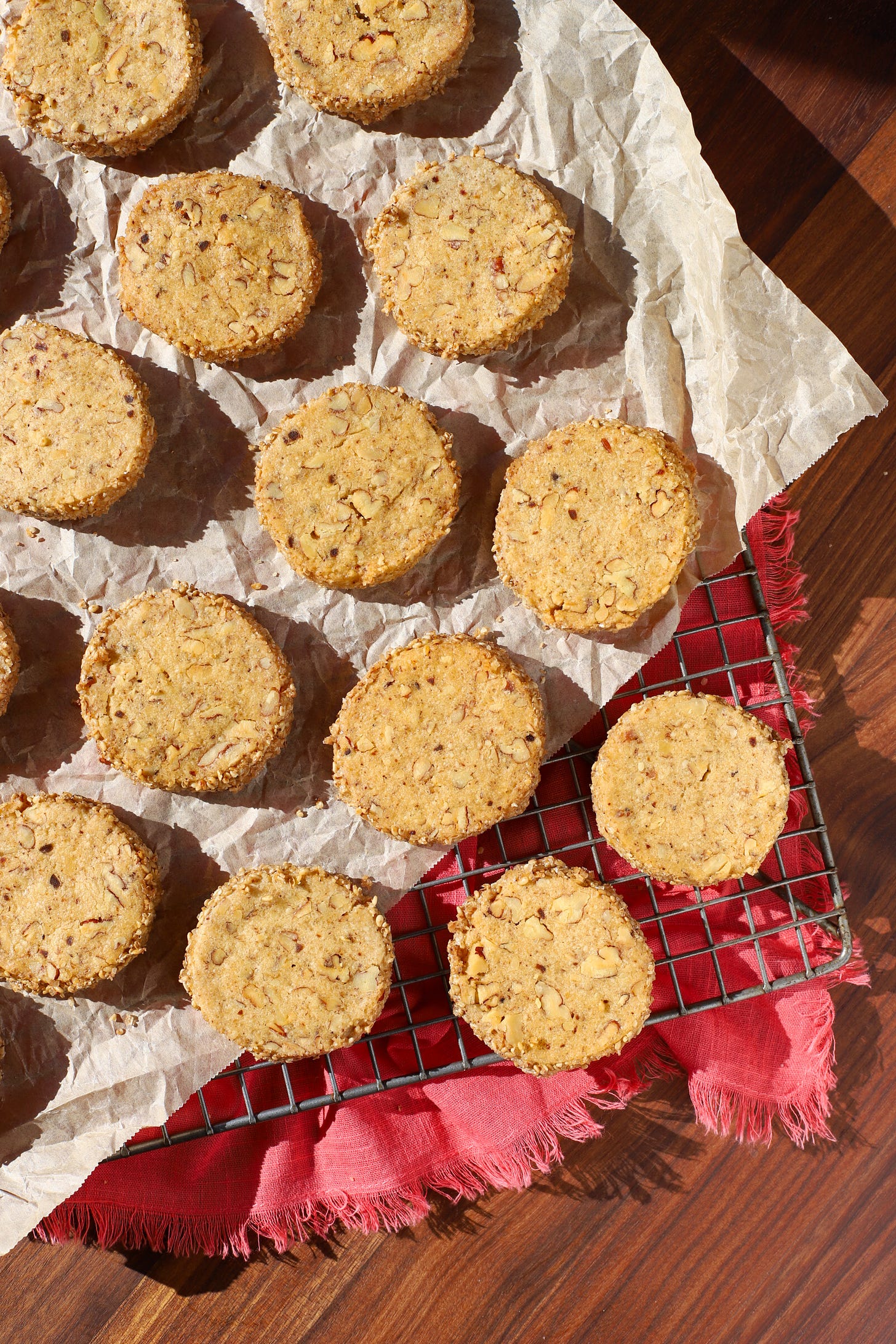 Baking rack with pecan cookies on a piece of parchment paper