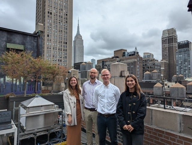 A group of people standing on a rooftop

Description automatically generated