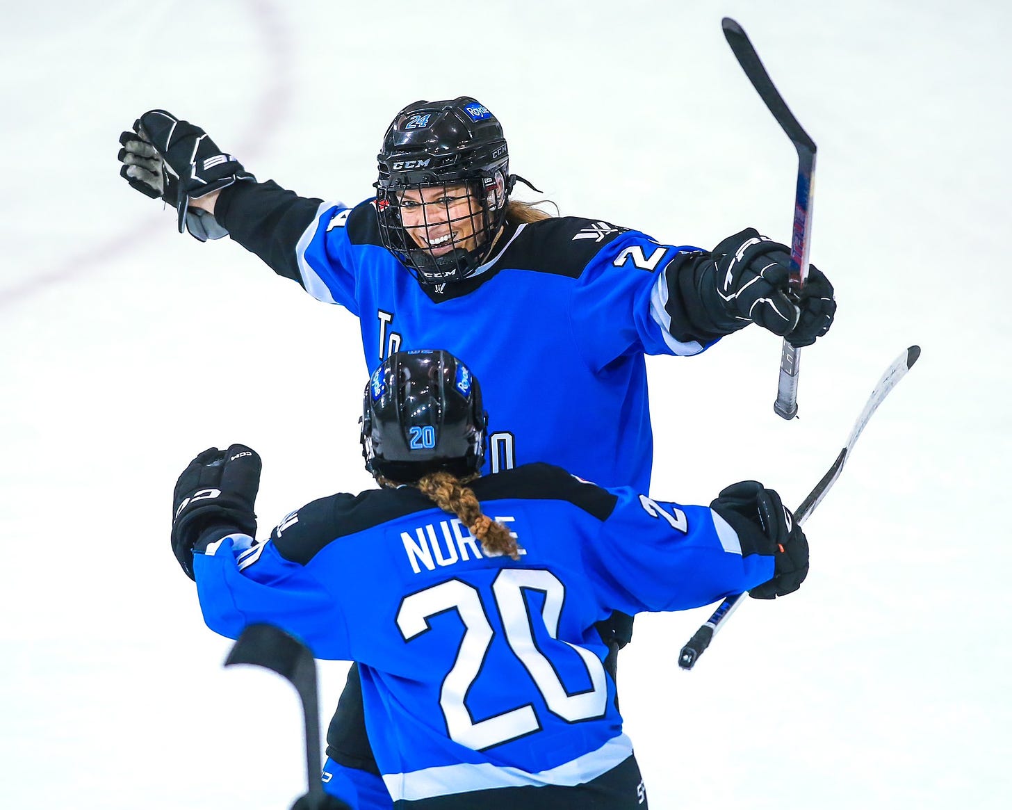 Natalie Spooner celebrates scoring a goal while Sarah Nurse skates up to celebrate along with her.