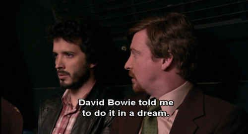 This may contain: two men sitting next to each other in front of a dark background with the words david bovie told me to do it in a dream
