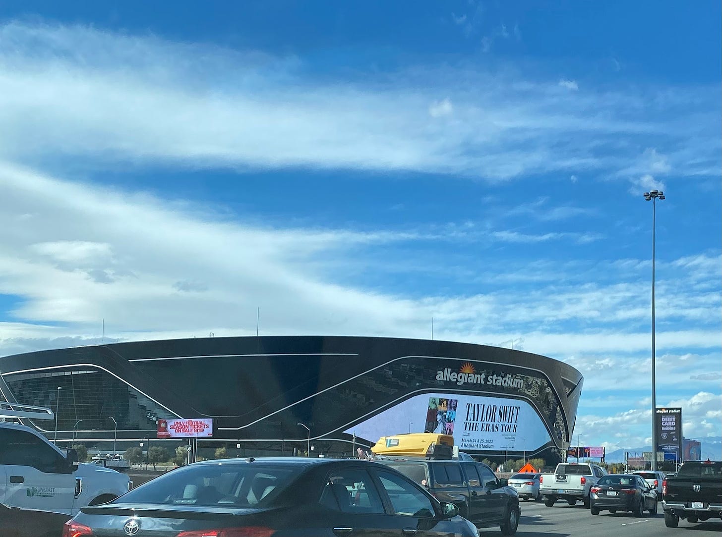 Allegiant Stadium with an ad for Taylor Swift's The Eras Tour on its screen, taken from the highway.