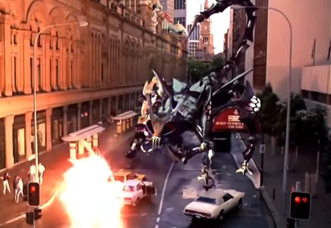 Screenshot do filme Power Rangers, o filme, mostrando o Scorpitron explodindo alguma coisa na rua