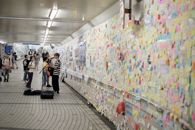 Subway station with colorful Post-Its on the walls, with personal messages and calls.