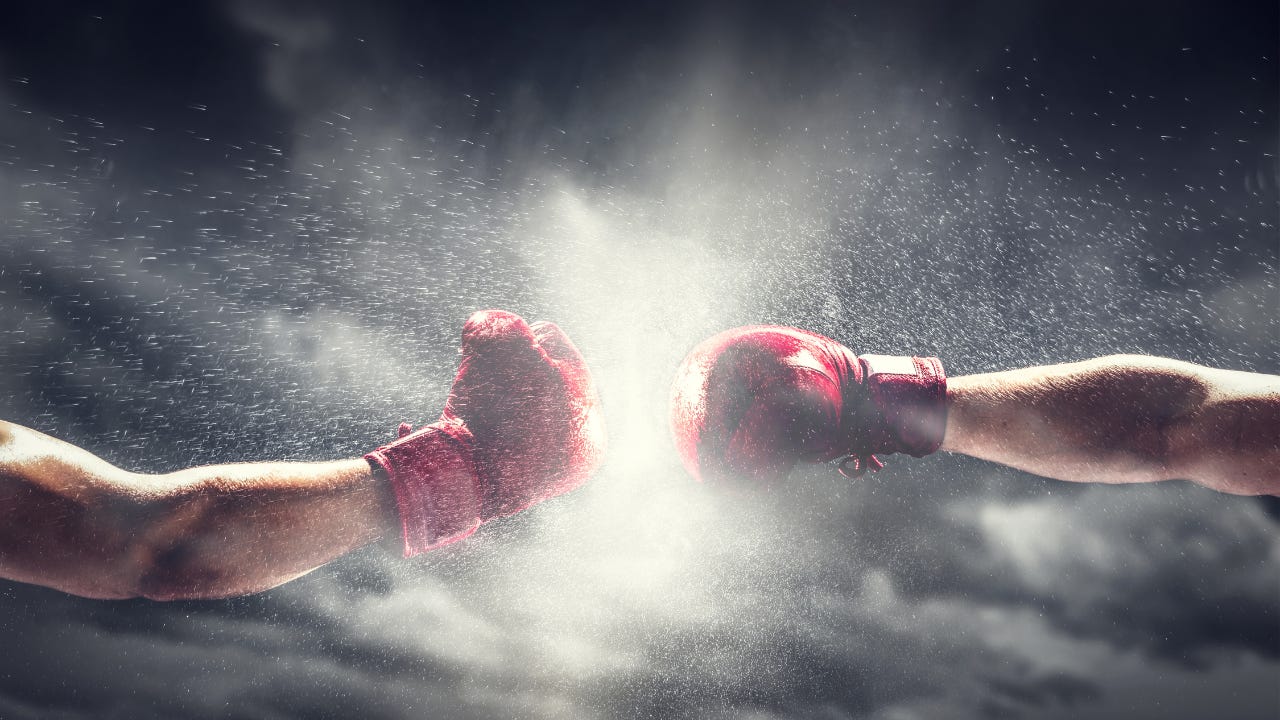 Two boxing gloves hitting each other.