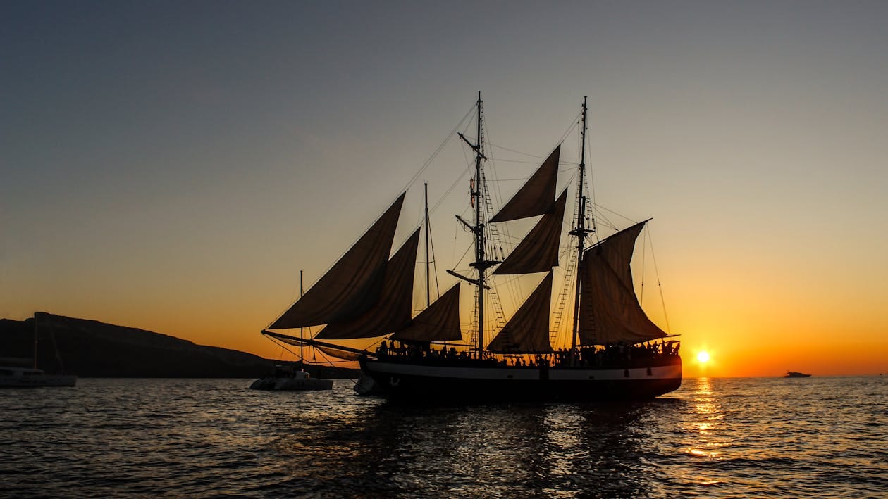 Free Silhouette of a Pirate Ship Sailing on Sea during Golden Hour Stock Photo